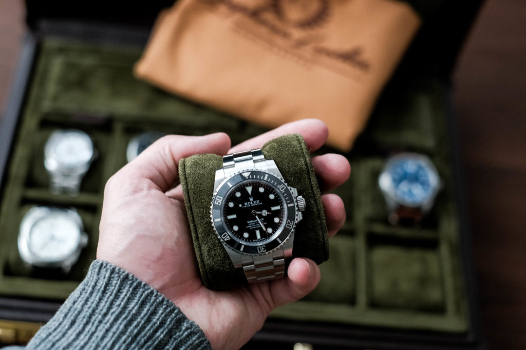 Rolex submariner in hand with case in background